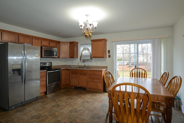 kitchen featuring sink, stainless steel appliances, and a chandelier