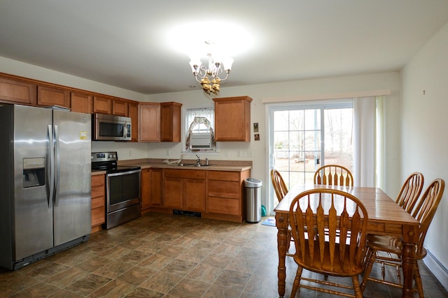 kitchen featuring sink, stainless steel appliances, and a notable chandelier