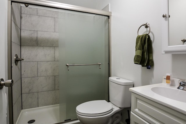 bathroom with vanity, toilet, and a shower with door