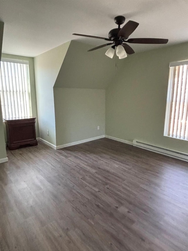 bonus room with baseboard heating, a wealth of natural light, ceiling fan, and dark hardwood / wood-style floors