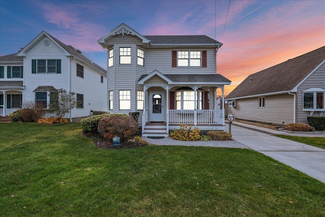 view of front facade with a lawn and covered porch