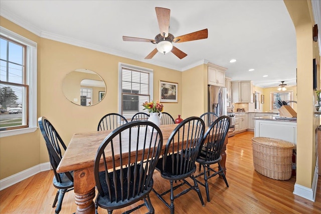 dining space featuring light hardwood / wood-style floors, a wealth of natural light, and ornamental molding