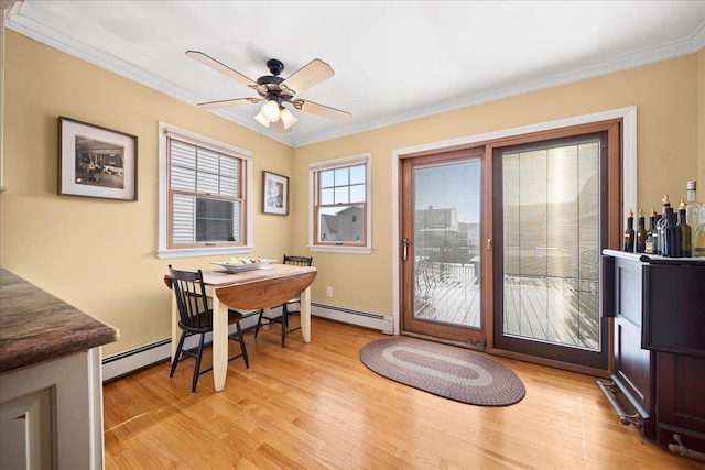 dining room featuring a baseboard heating unit, light wood-type flooring, ceiling fan, and ornamental molding