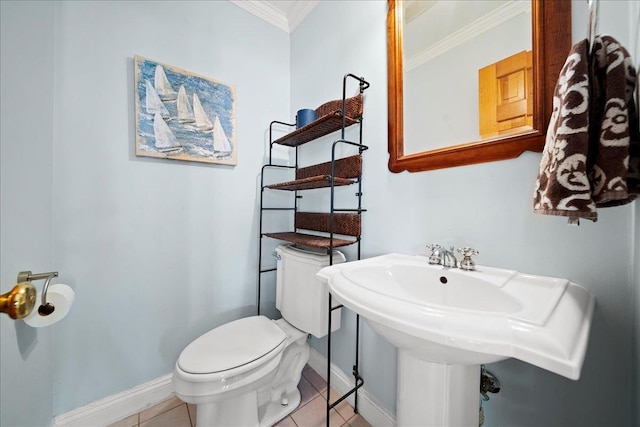 bathroom with toilet, tile patterned floors, crown molding, and sink