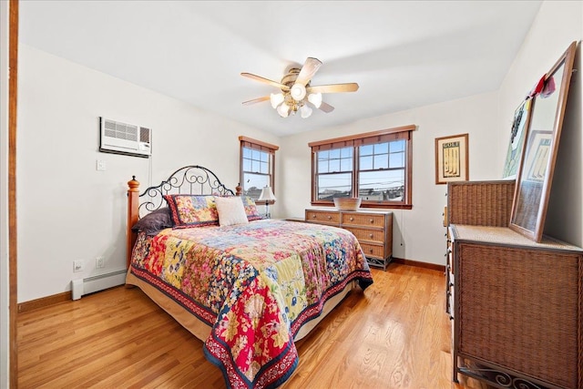 bedroom with ceiling fan, light hardwood / wood-style floors, a wall mounted AC, and a baseboard radiator