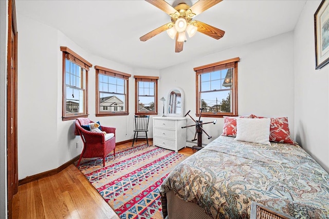 bedroom featuring multiple windows, ceiling fan, and hardwood / wood-style flooring