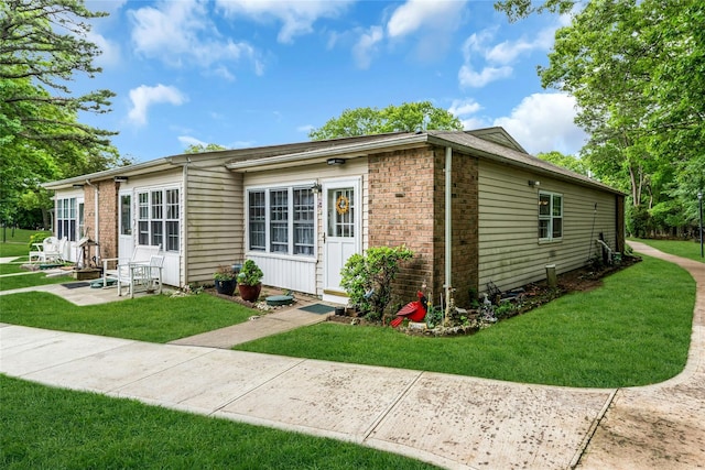 423 Woodbridge Unit D, Ridge, NY 11961 - view of home's exterior featuring brick siding, a lawn, and entry steps