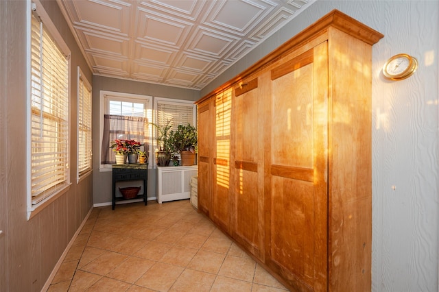 hallway featuring radiator heating unit and light tile patterned flooring