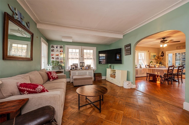 living room with ceiling fan, parquet floors, and a wealth of natural light