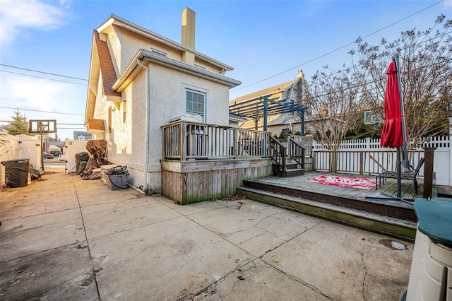 back of property featuring a patio area and a wooden deck