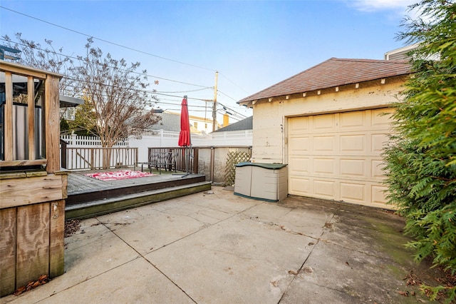 view of patio / terrace with a wooden deck, an outdoor structure, and a garage