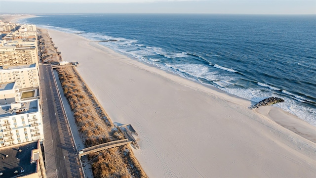 drone / aerial view with a water view and a beach view