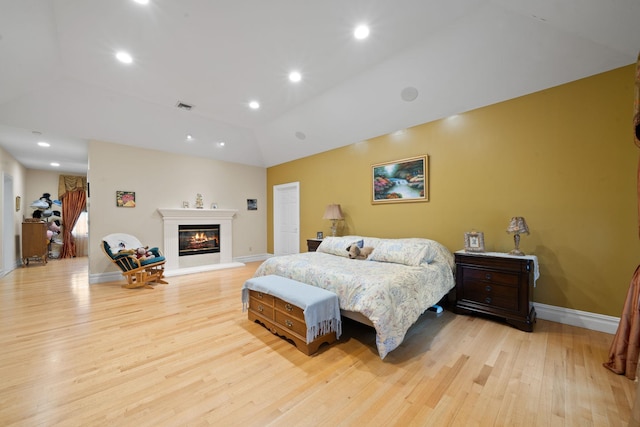 bedroom featuring light wood-type flooring and lofted ceiling