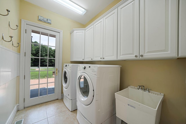 laundry room featuring separate washer and dryer, sink, light tile patterned floors, and cabinets