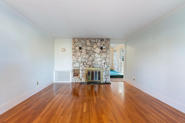 unfurnished living room with a fireplace, wood-type flooring, and ornamental molding