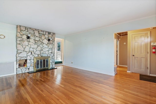 unfurnished living room with a fireplace, ornamental molding, and light wood-type flooring