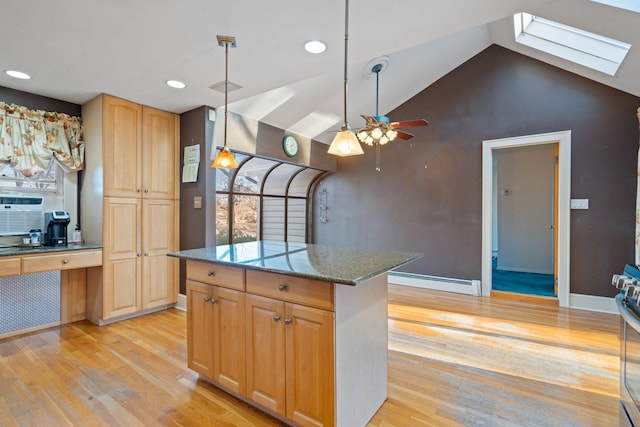 kitchen featuring ceiling fan, a center island, a baseboard radiator, vaulted ceiling with skylight, and light wood-type flooring