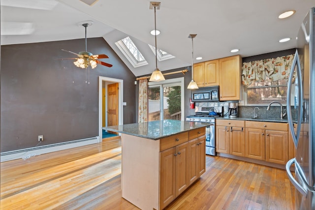 kitchen with a center island, vaulted ceiling with skylight, light wood-type flooring, baseboard heating, and stainless steel appliances