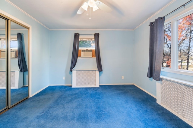 carpeted spare room with radiator heating unit, a wealth of natural light, and ceiling fan