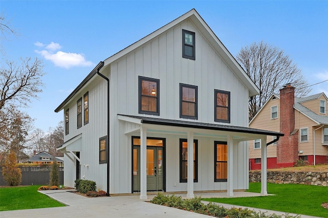 modern inspired farmhouse with a front lawn and a porch