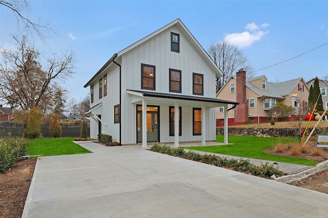 modern farmhouse featuring covered porch and a front lawn