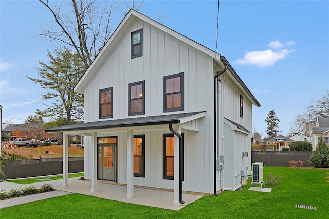 back of house with a yard and central AC unit