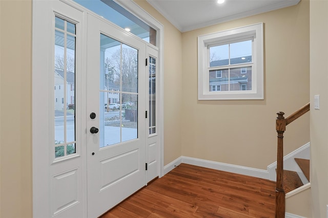 doorway to outside featuring dark hardwood / wood-style flooring, a wealth of natural light, and crown molding