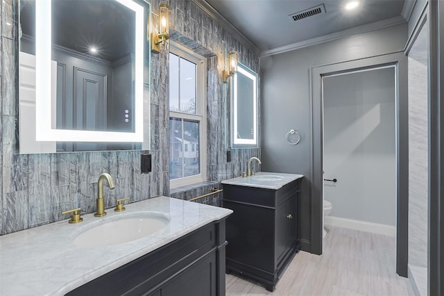 bathroom featuring vanity, toilet, tile walls, and ornamental molding