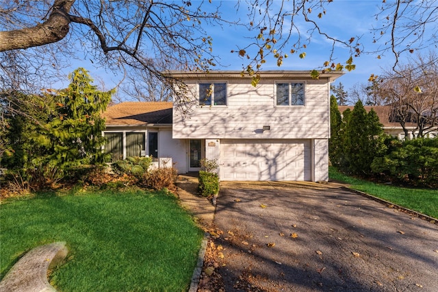 tri-level home featuring a garage and a front lawn