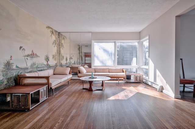 living room featuring baseboard heating, wood-type flooring, and a textured ceiling