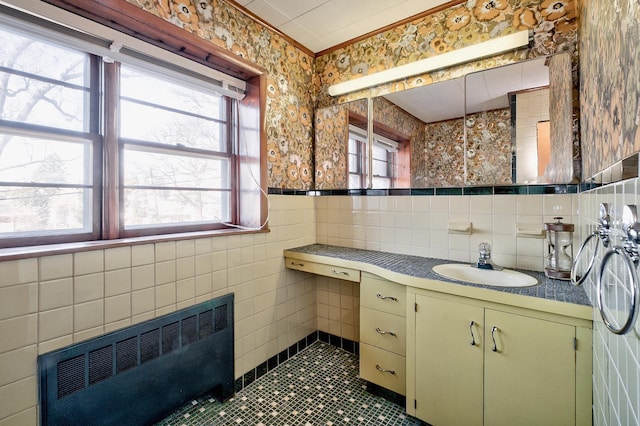 bathroom featuring tile patterned flooring, radiator, tile walls, and vanity