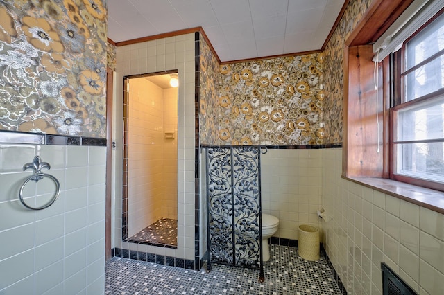 bathroom with crown molding, tile walls, and walk in shower