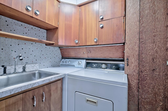 washroom with independent washer and dryer, sink, and cabinets