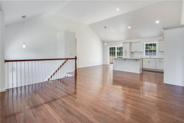 unfurnished living room featuring hardwood / wood-style floors and high vaulted ceiling