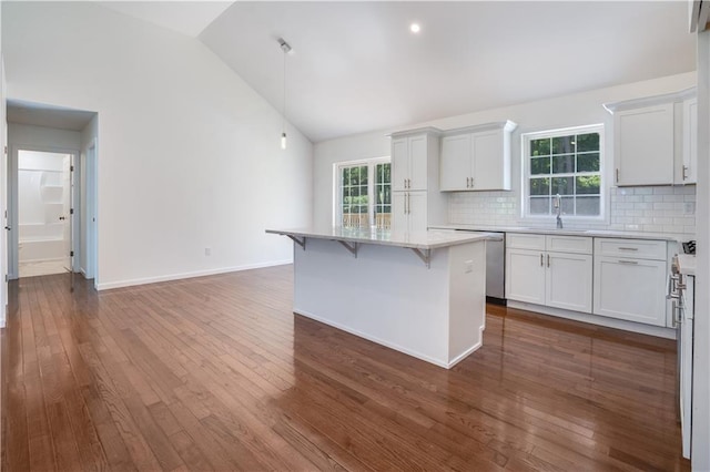 kitchen featuring dark hardwood / wood-style floors, a kitchen island, decorative backsplash, and white cabinetry