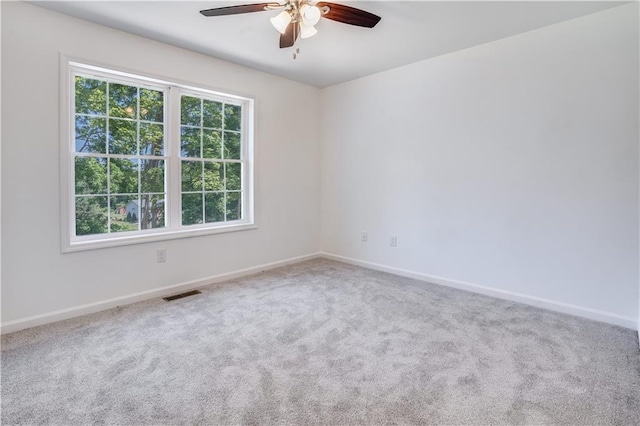 carpeted spare room featuring ceiling fan