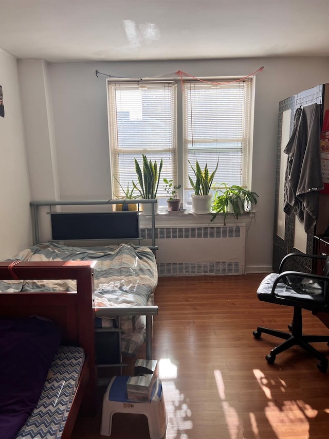 bedroom featuring wood-type flooring and radiator