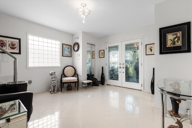 living area featuring a wealth of natural light, french doors, light tile patterned floors, and an inviting chandelier