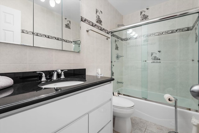 full bathroom featuring vanity, backsplash, tile patterned flooring, enclosed tub / shower combo, and tile walls