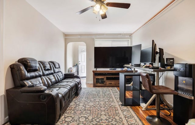 living room featuring hardwood / wood-style floors, ceiling fan, and crown molding