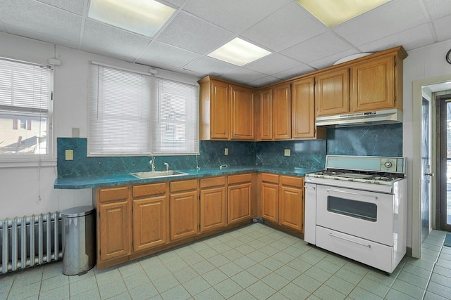 kitchen with radiator heating unit, white range, a drop ceiling, and sink