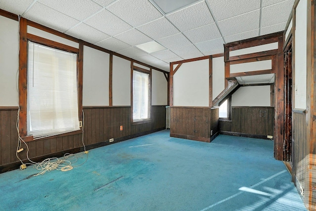 empty room with a drop ceiling and light colored carpet