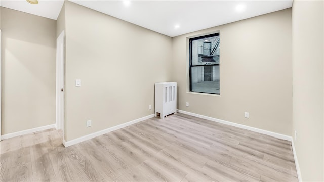 empty room featuring light hardwood / wood-style floors and radiator heating unit