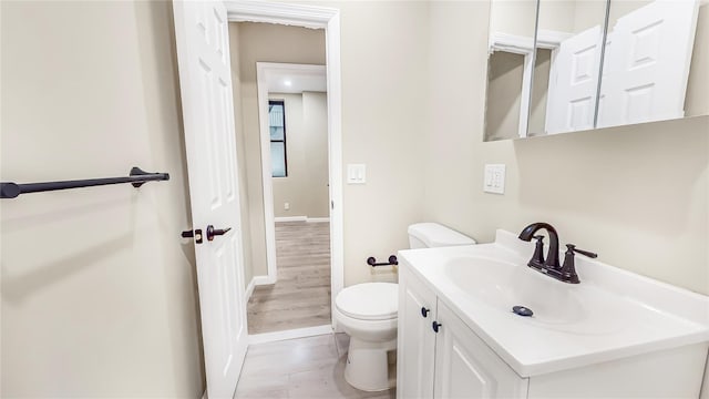 bathroom featuring vanity, hardwood / wood-style flooring, and toilet