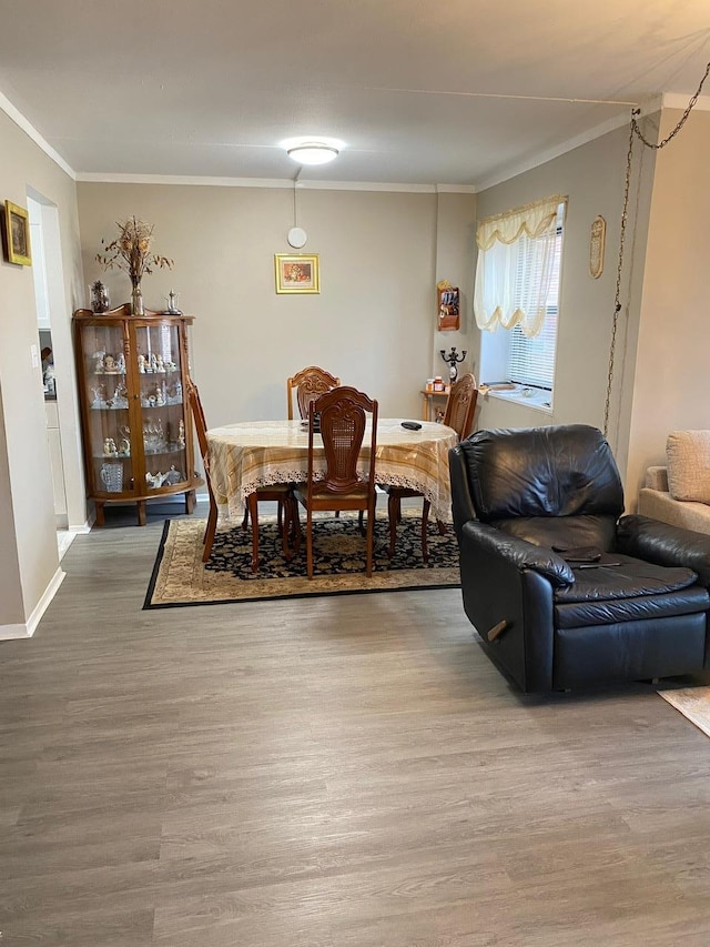 dining area featuring wood-type flooring and crown molding