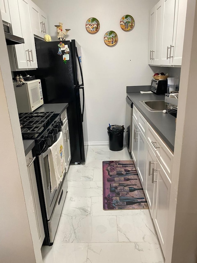 kitchen with appliances with stainless steel finishes, white cabinetry, exhaust hood, and sink