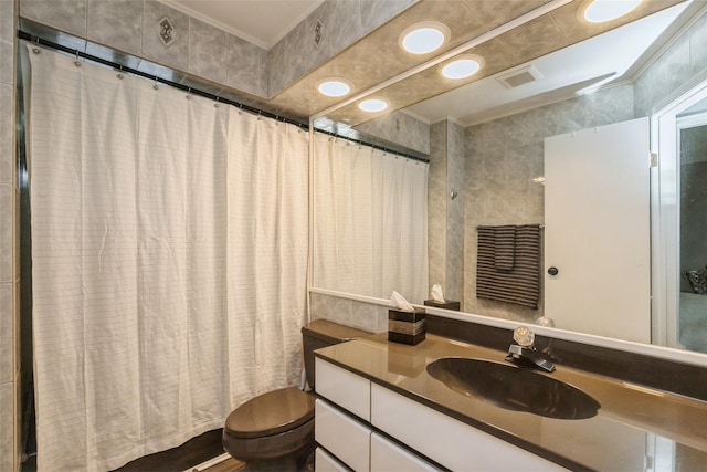 bathroom with tile walls, toilet, vanity, and a shower with shower curtain