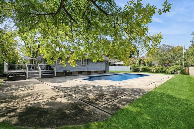 view of swimming pool with a deck, a yard, and a patio area