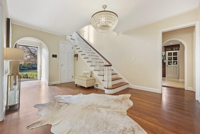 staircase featuring wood-type flooring and a notable chandelier