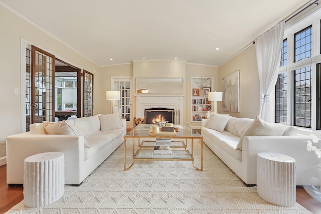 living room featuring ornamental molding, light hardwood / wood-style floors, and french doors